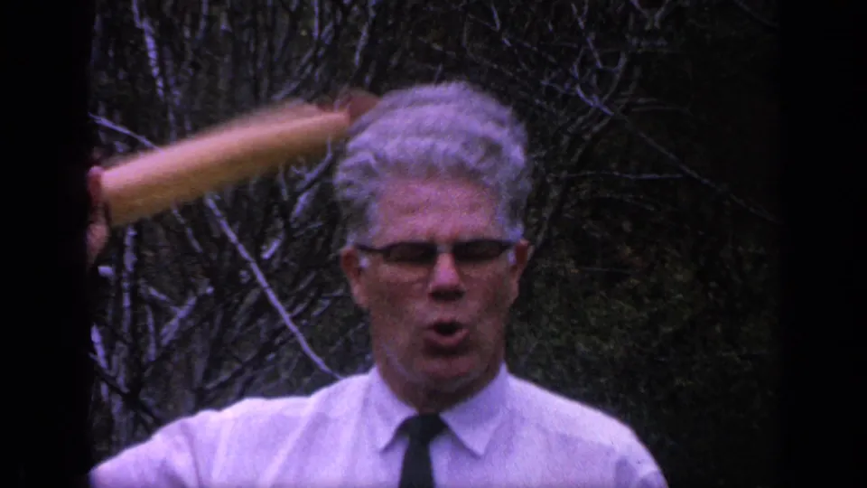 In the 1968 Florida frame, the man opens his mouth as a wooden rolling pin is held against the side of his head.