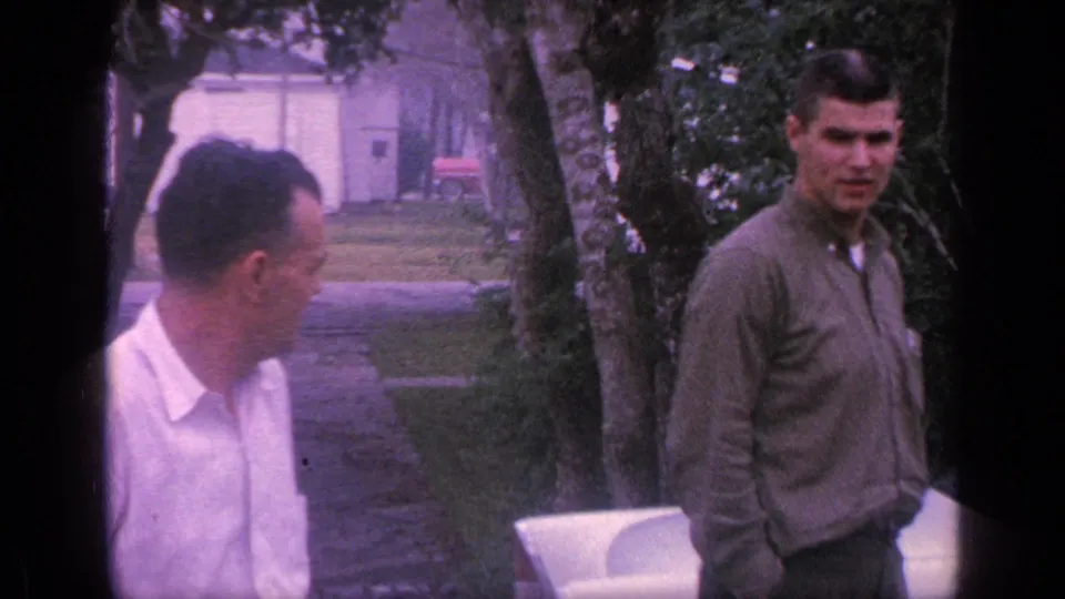 At the end of the brief 1968 Florida clip, the older man turns aside as the younger man faces toward the camera in the yard.