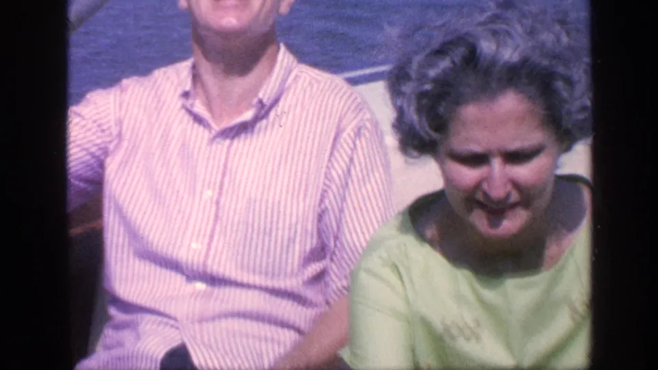 A woman in a pale green top sits beside a man on a small boat in 1968 Florida home-movie footage.