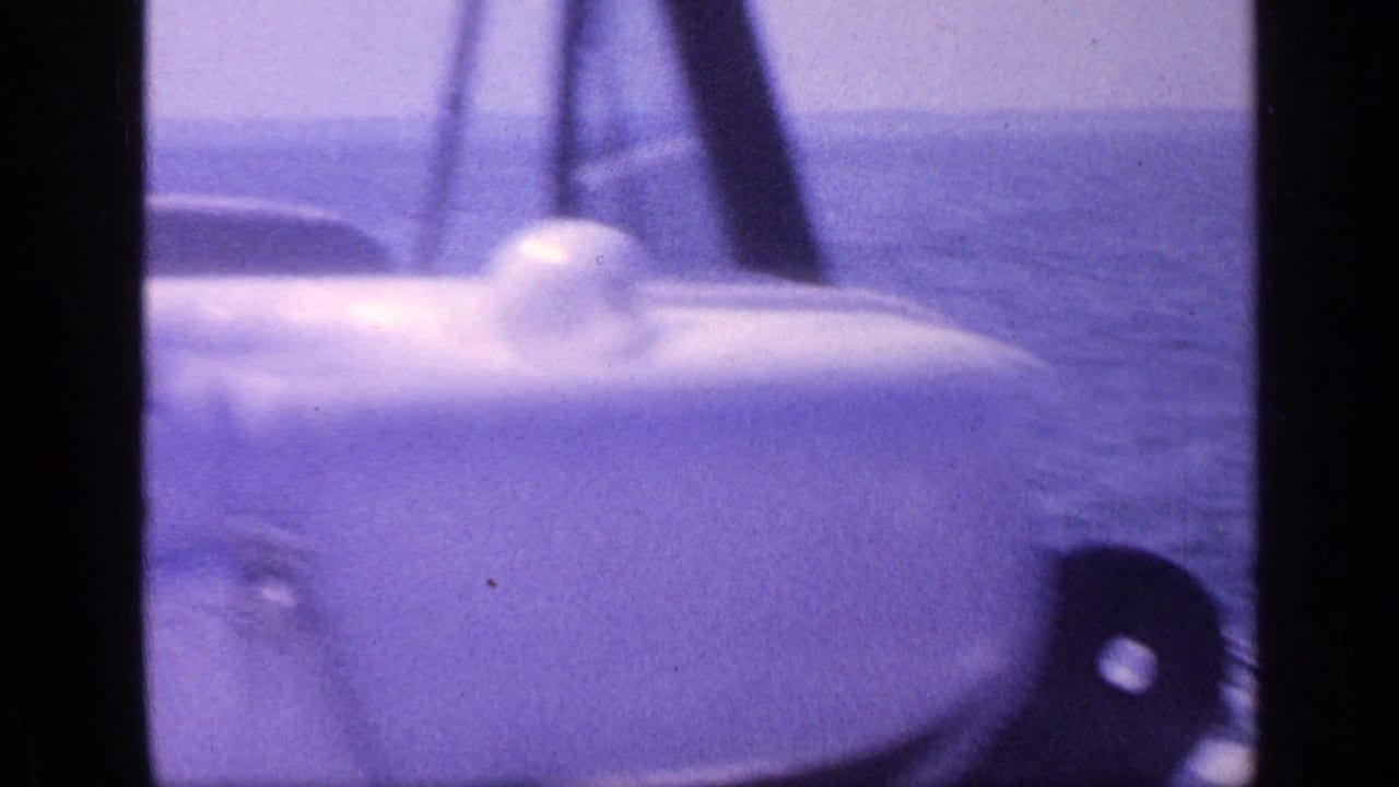 Soft 8mm view from a Florida boat, focused on white railings and a rounded deck light against the sea.