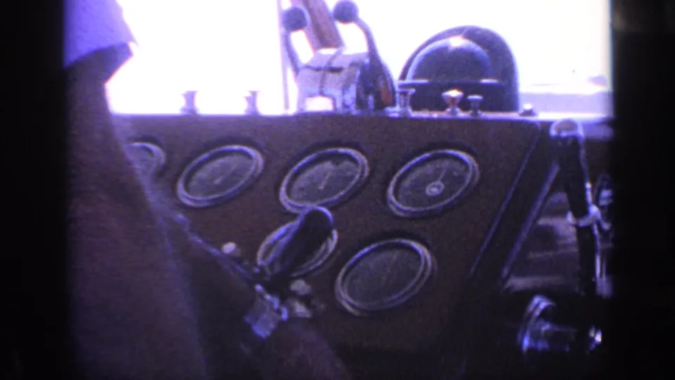 Final 1968 Florida cockpit frame showing the boat's round instrument gauges, helm fittings, and a partial figure at the dashboard.