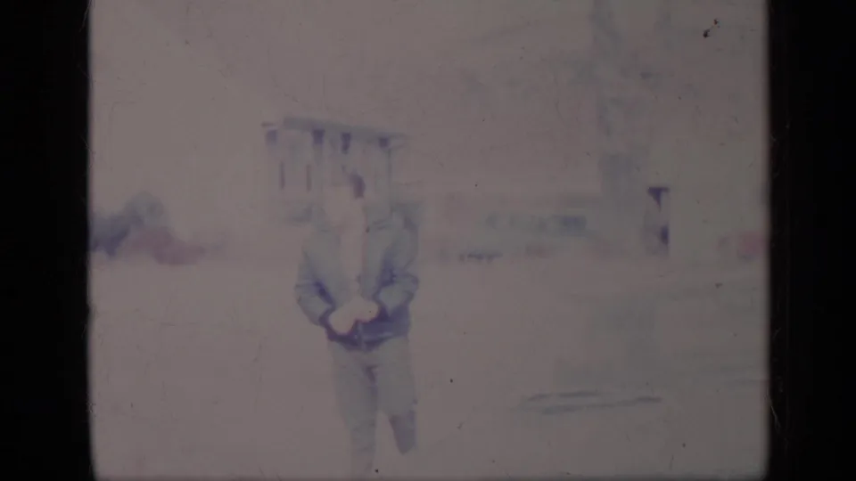 A man in a jacket appears near a light-colored classic car in soft, faded 1969 California 8mm home-movie footage.