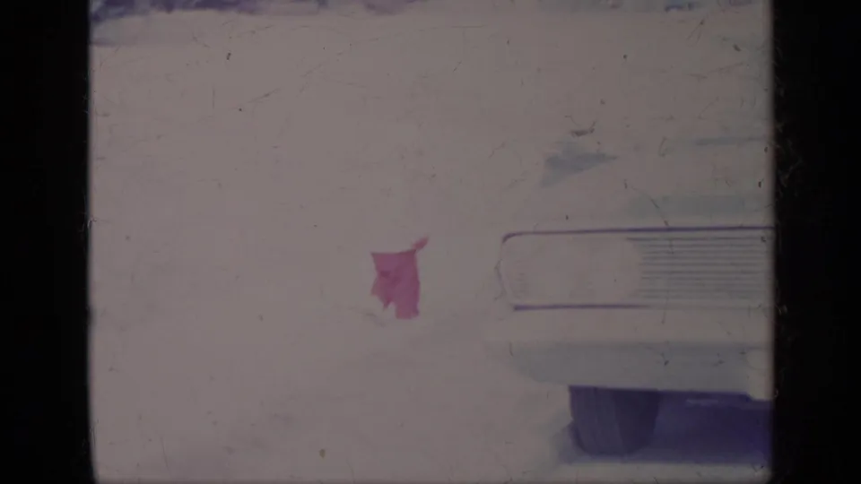 1969 California 8mm frame showing the front corner of a white car and a small pink garment-like shape near the lower left.