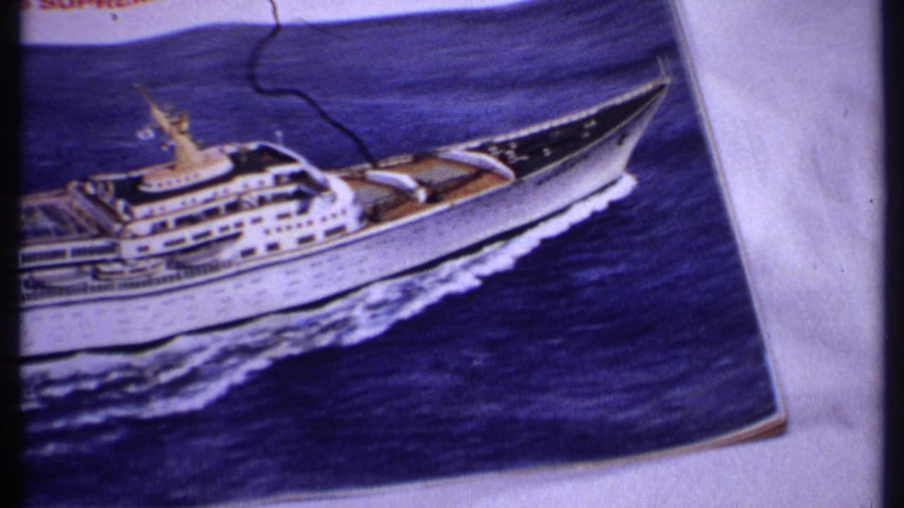 Printed photograph of a white cruise ship on blue ocean water, partly cropped on the left.