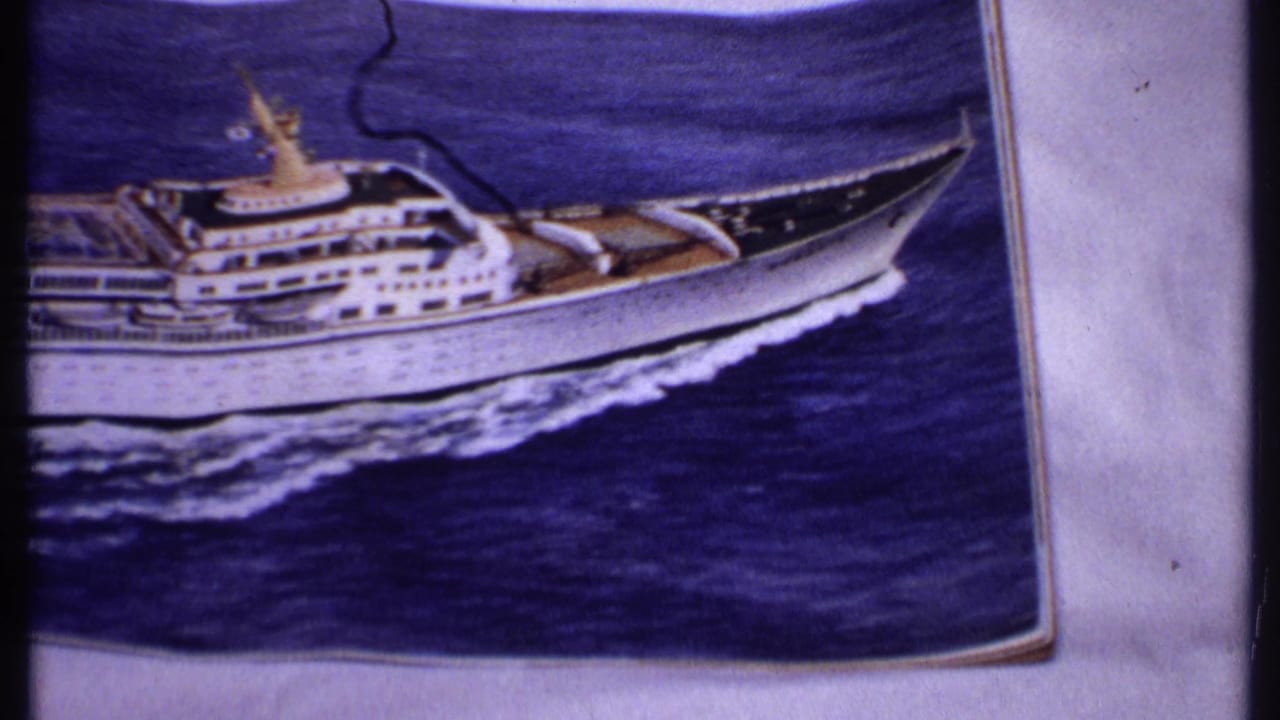 Printed cruise ship photograph with the ship centered against dark blue water.