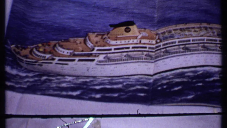 A closer view of the printed white cruise ship emphasizes the hull, decks, funnel, dark blue water, and aged 8mm frame edges.