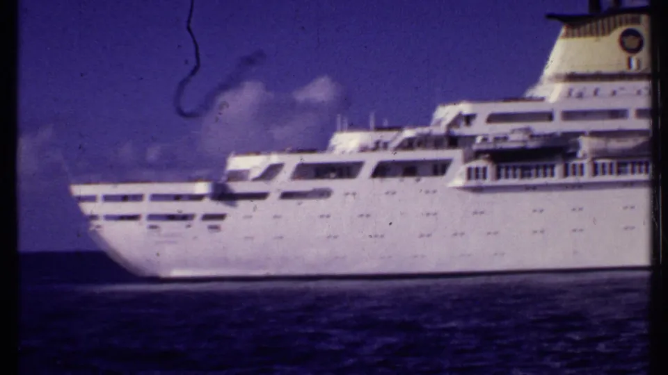 1969 Bahamas home-movie frame showing the aft section of a large white passenger ship on the ocean with visible decks and funnel.