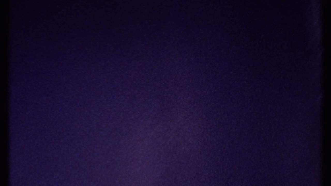 Purple-blue film frame with no distinct subject visible.