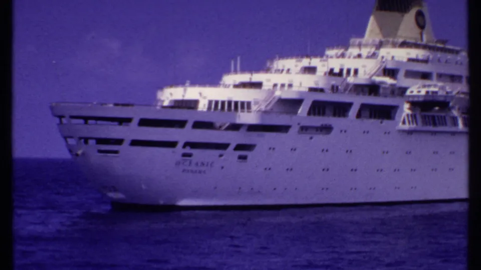 1969 Bahamas-associated frame with the cruise ship bow, bridge area, funnel, and dark window bands visible against ocean and sky.
