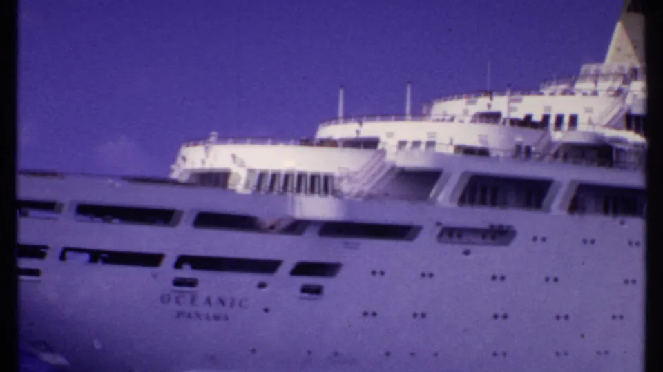 1969 Bahamas home-movie frame showing the Oceanic Panama name on the hull below decks and lifeboats.