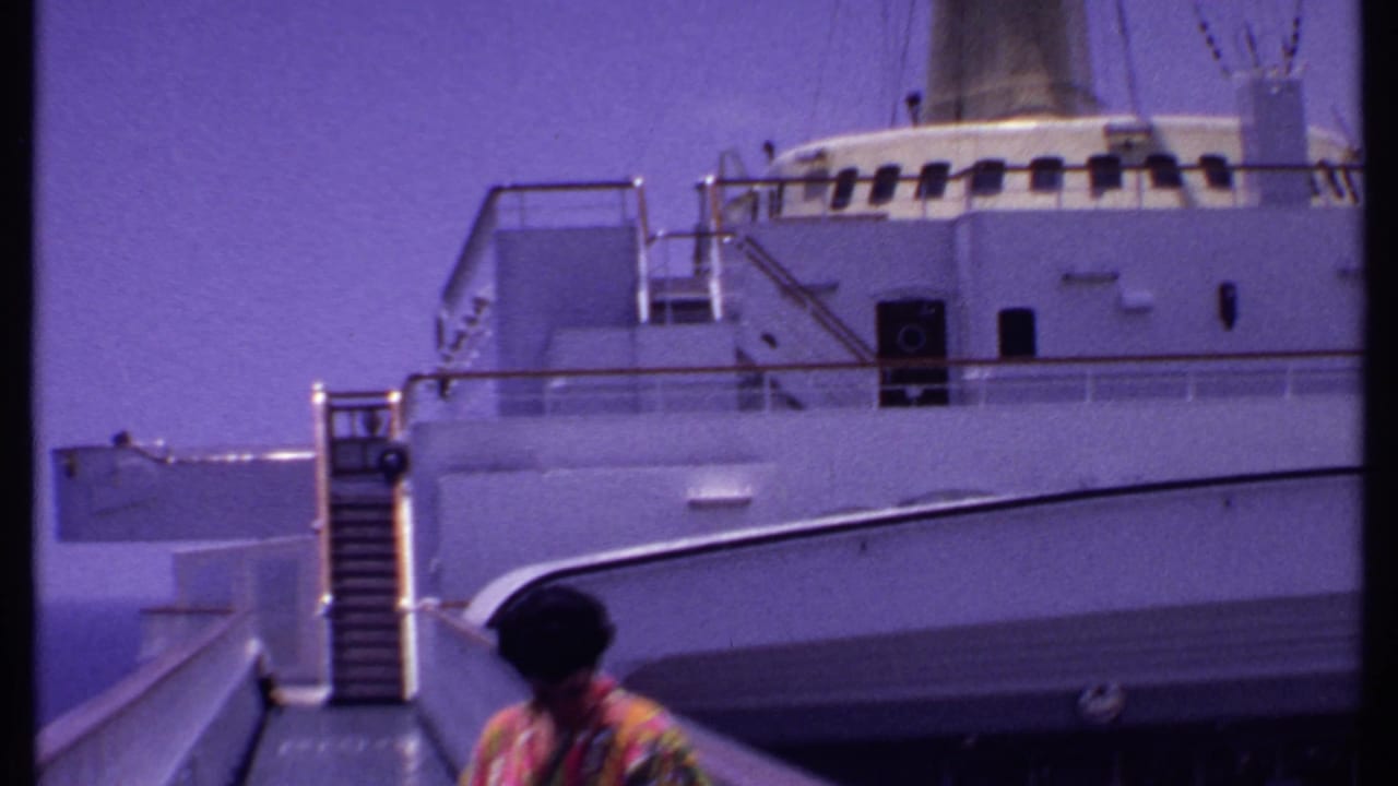 White cruise ship exterior and gangway with a woman partly visible near the lower edge.