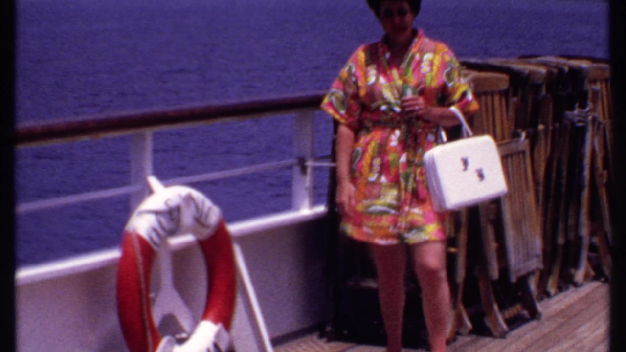 Woman in a colorful dress holding a white handbag near a life preserver on deck.