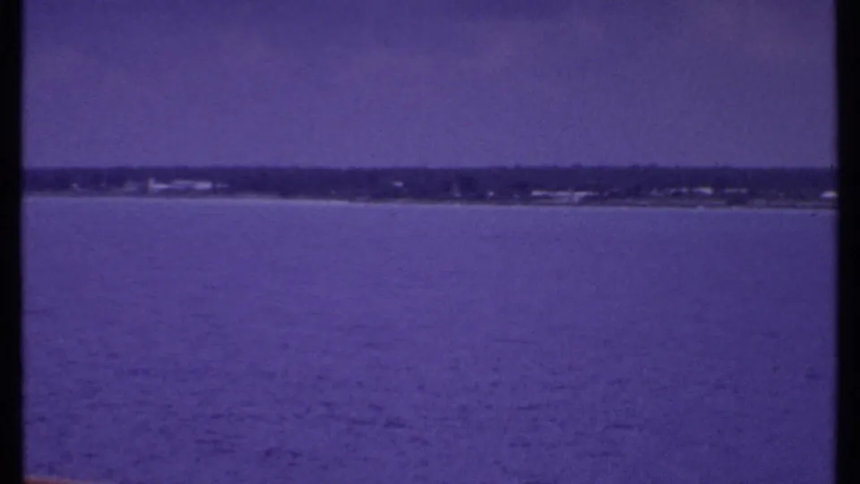 A view from the cruise ship shows blue water and a low distant shoreline, likely part of the same 1969 Bahamas home-movie sequence.