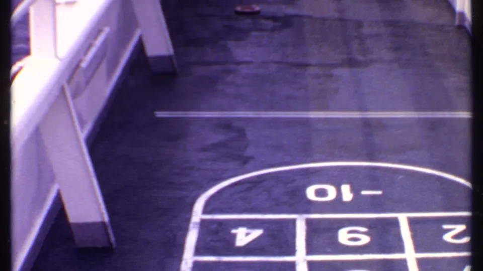 Close view of a painted shuffleboard scoring area on a ship deck, consistent with the 1969 Bahamas travel footage.