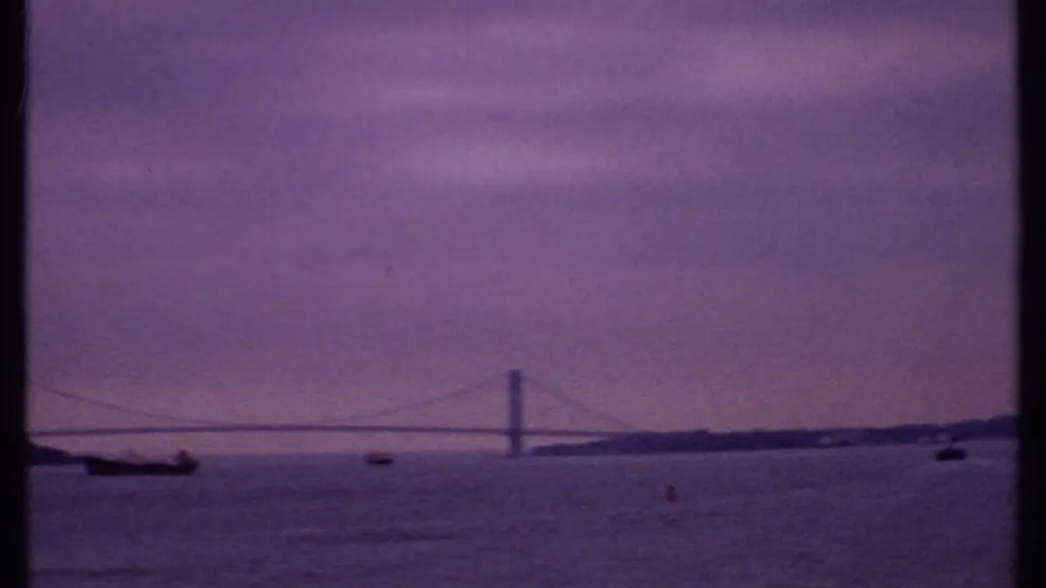 1969 Bahamas home-movie view of a bridge crossing the horizon with boats scattered across the water below.