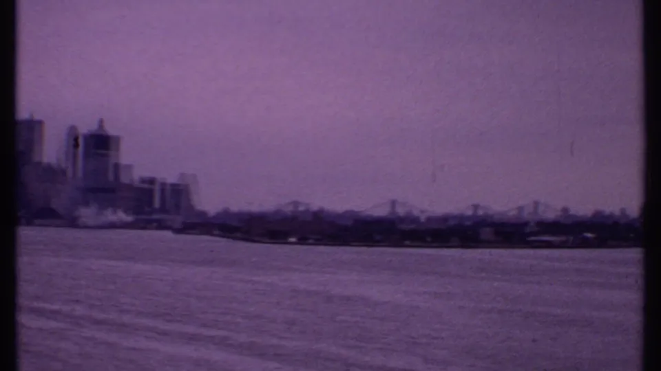 1969 Bahamas 8mm view of high-rises along the shoreline and a distant suspension bridge over water.