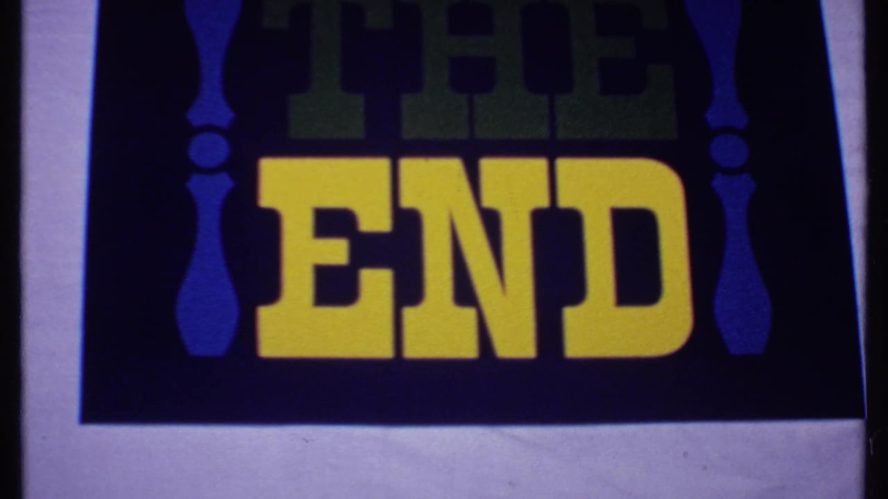 1969 Bahamas 8mm frame showing a vintage THE END title card with yellow lettering, green shadow text, and blue side ornaments.