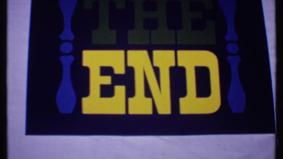 1969 Bahamas 8mm frame showing a vintage THE END title card with yellow lettering, green shadow text, and blue side ornaments.