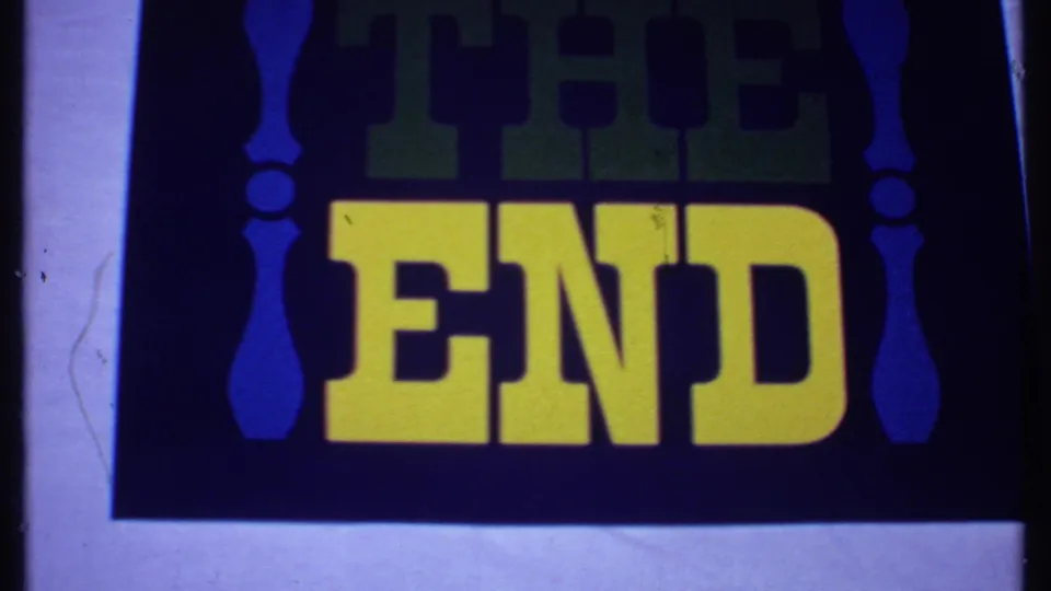 Final 1969 8mm Bahamas frame of the vintage THE END closing card, with saturated yellow text, blue scroll-like sides, and soft focus.