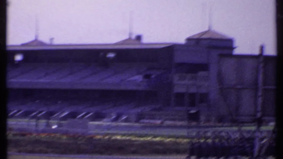 1969 India frame showing a large covered grandstand with a side tower and foreground grounds in soft 8mm color.