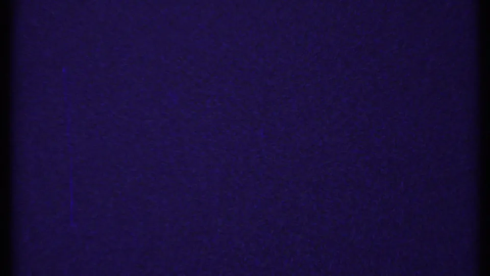 Dark, grainy purple 8mm frame, likely leader or an underexposed transition with no clear subject visible.