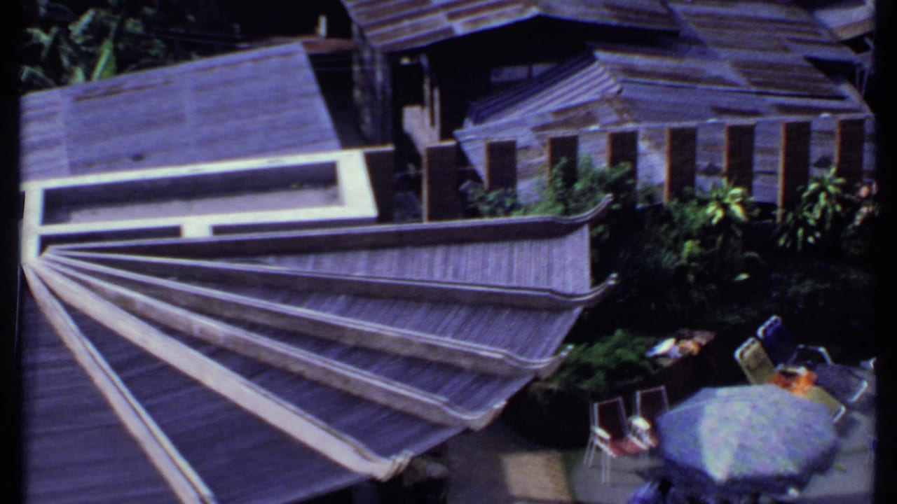 Terrace with tiered roofs, plants, parasols, deck chairs, and small tables.