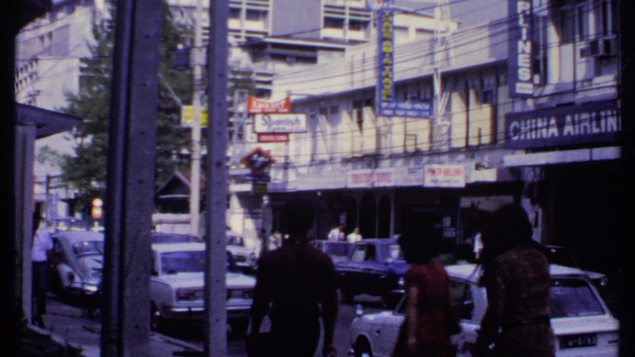 1969 India commercial street with pedestrians, older cars, a Beetle, storefront signs, and a visible China Airlines sign.