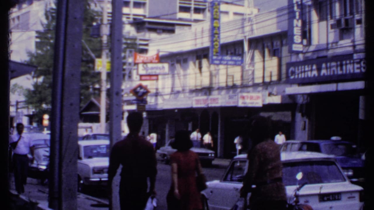 1969 India street view with pedestrians, period cars, overhead wires, shop signs, and a prominent China Airlines storefront sign.