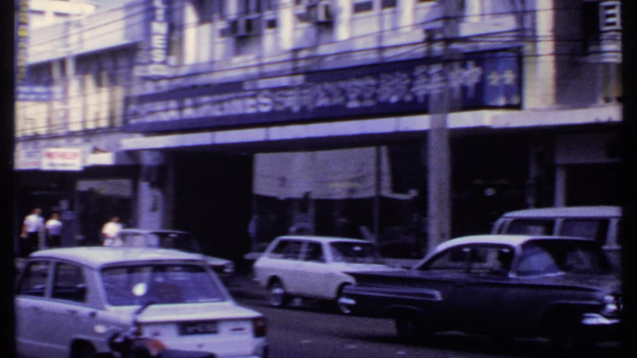 1969 India street traffic with a white sedan, dark sedan, station wagon, storefront signs, and the China Airlines sign partly visible.