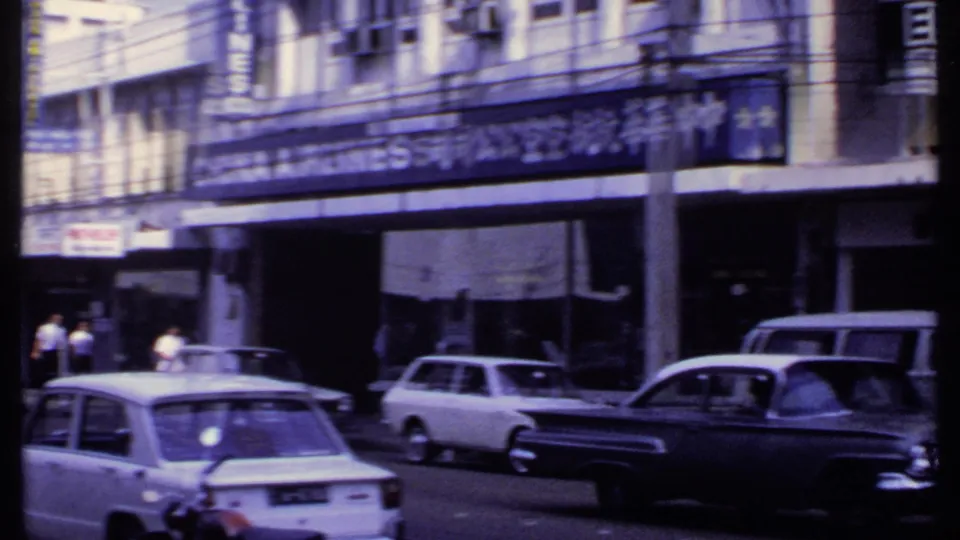 1969 India street traffic with a white sedan, dark sedan, station wagon, storefront signs, and the China Airlines sign partly visible.