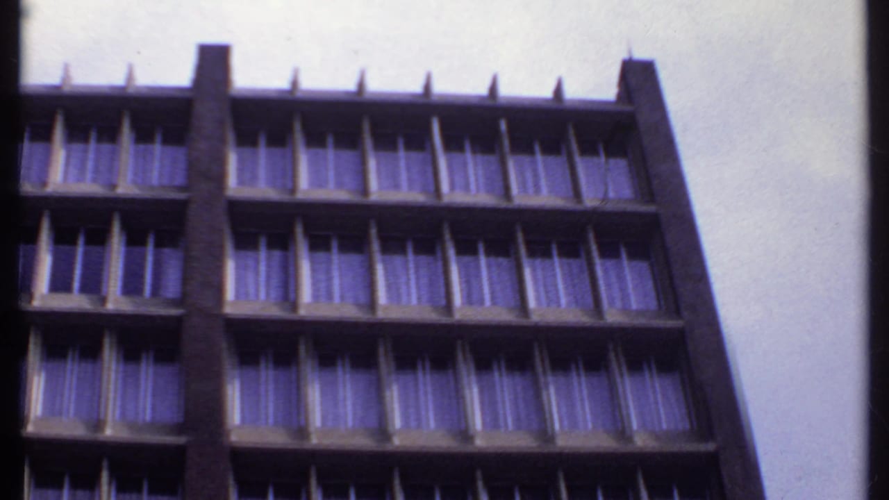 1969 India 8mm frame of the high-rise motel facade, with uniform curtained windows and projecting concrete balcony dividers.