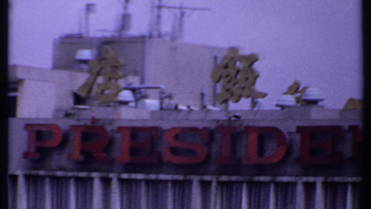 1969 India 8mm frame showing the PRESIDENT portion of the hotel sign beneath gold characters and rooftop utilities.