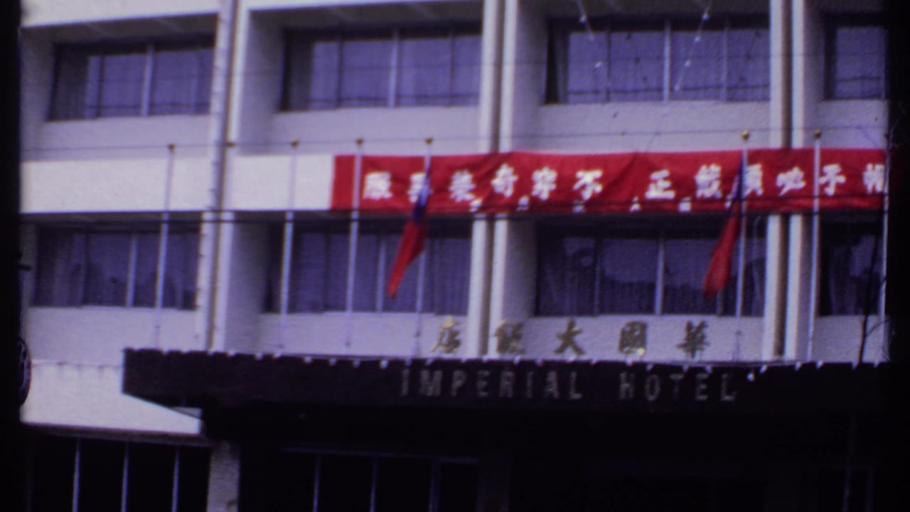 White hotel facade with red Chinese-character banner and Imperial Hotel sign.