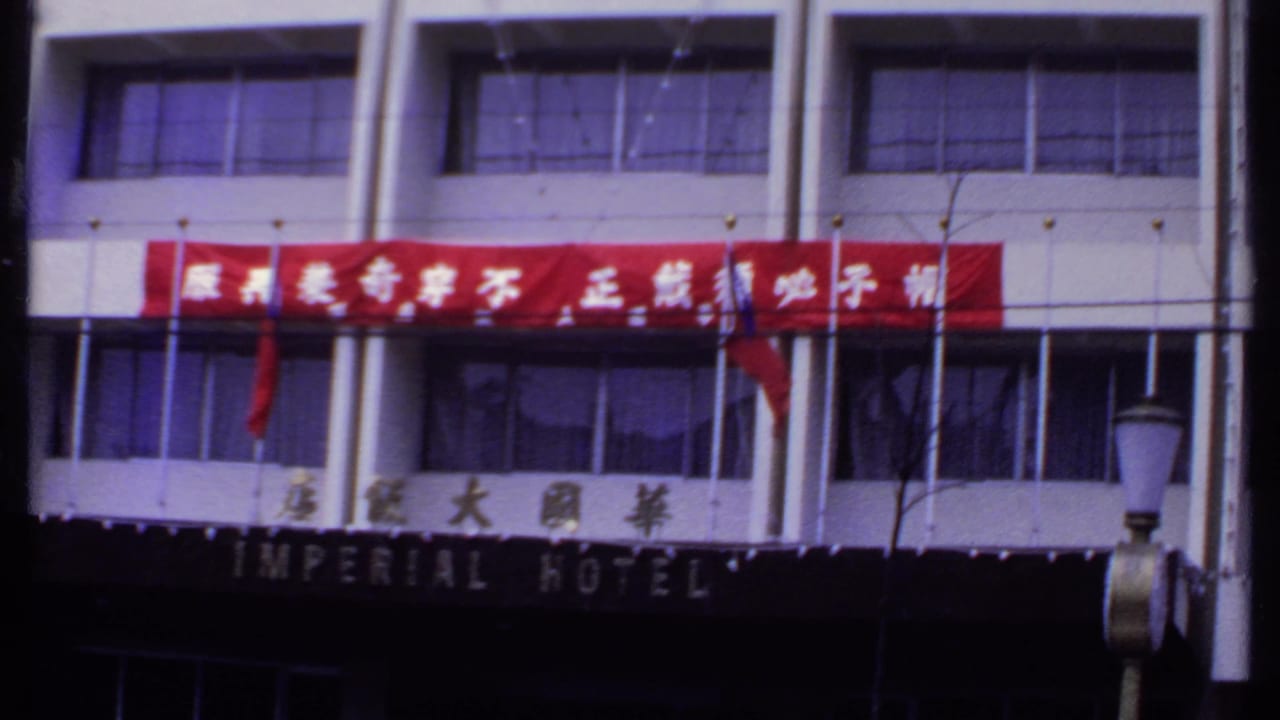 1969 India hotel exterior with the Imperial Hotel sign partly visible below a bright red Chinese-character banner and a streetlamp in front.