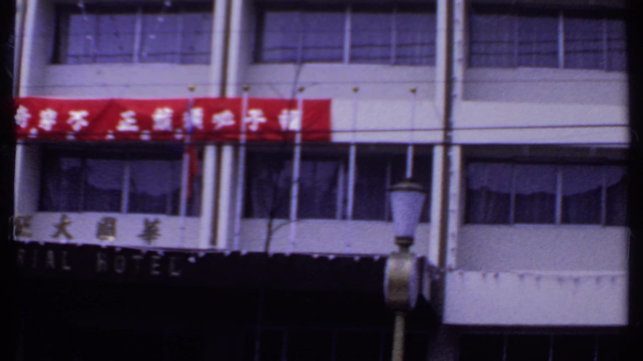 Building facade with red Chinese-character banner, Imperial Hotel sign, windows, and street lamp.
