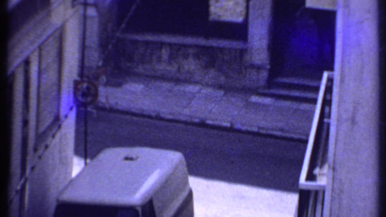 White van and adjacent building walls seen from an elevated angle.