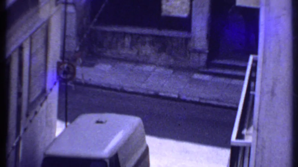 Elevated 8mm view in Kenya, 1969, with a white van parked near exterior walls and railings.