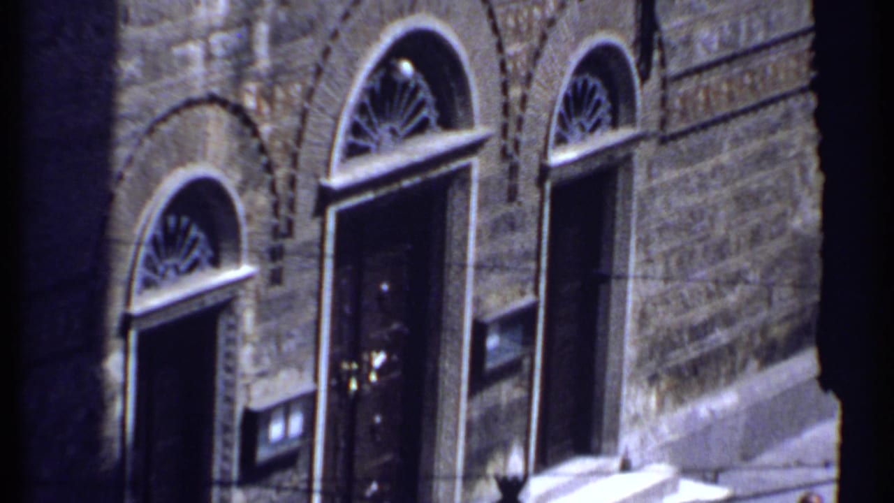 Arched doorways and windows on a stone building exterior.