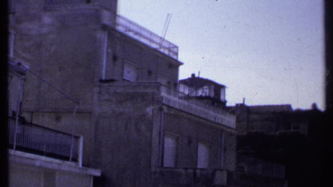 Close view of an old building facade with balcony and roof structure.