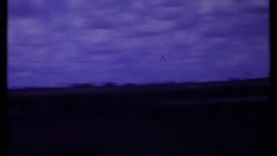 1969 Kenya 8mm landscape frame showing open savannah and a low horizon beneath a purple clouded sky.