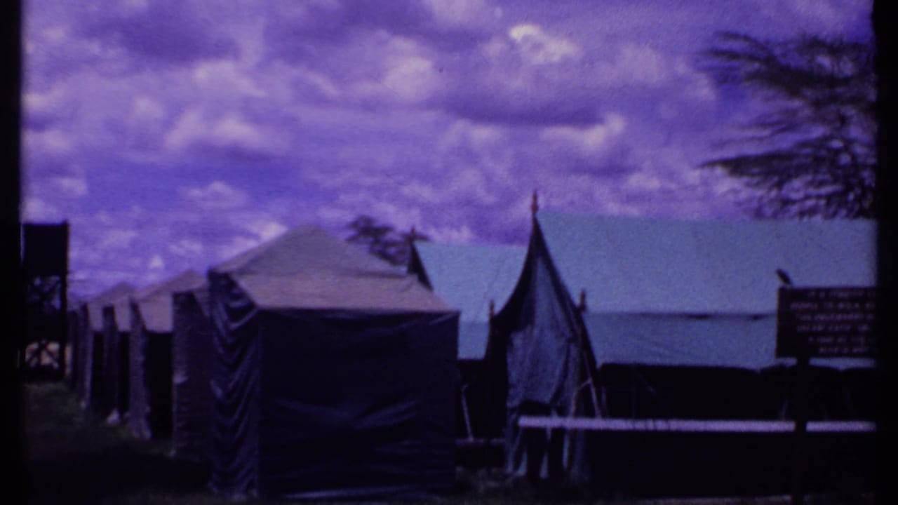 Canvas tents and an elevated water tank under a purple-tinted sky.