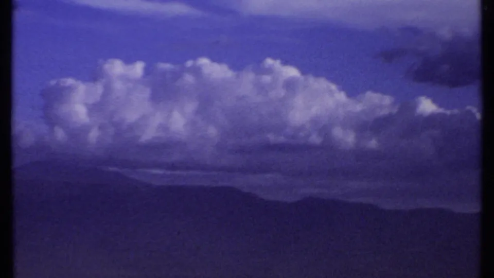 The final 1969 Kenya frame leaves the people and holds on purple-blue clouds, distant ridges and a broad valley landscape.