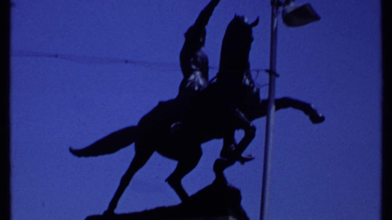 Mounted statue in dark silhouette with the horse and rider framed high against the sky.