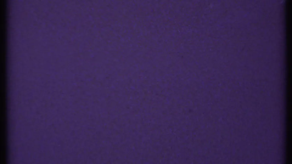 1969 New London 8mm frame with a mostly uniform blue-purple surface, dark gate-edge strip, grain, and faint dust markings.