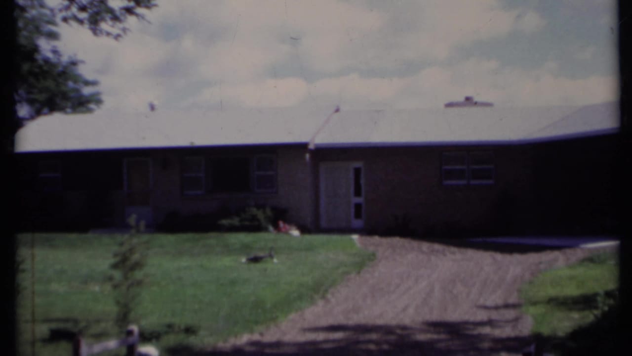 Single-story house with lawn and gravel driveway seen from outside.