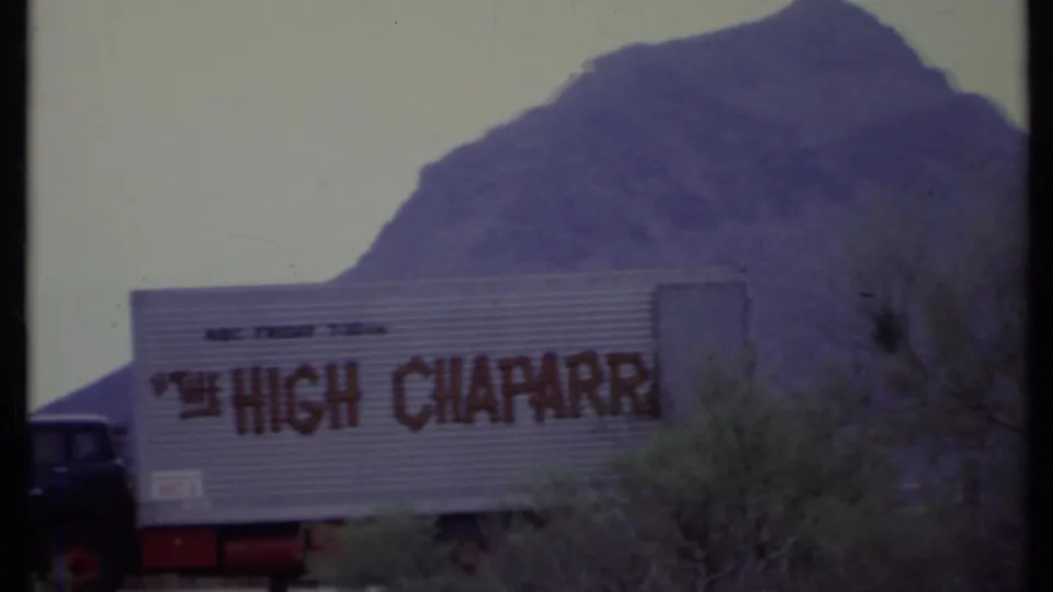 1971 California 8mm frame with a tractor-trailer bearing partial High Chaparral lettering in front of a desert mountain backdrop.