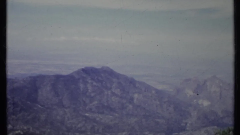 1971 California 8mm view of rocky mountain ridges fading into atmospheric haze, framed by a dark vertical film edge.