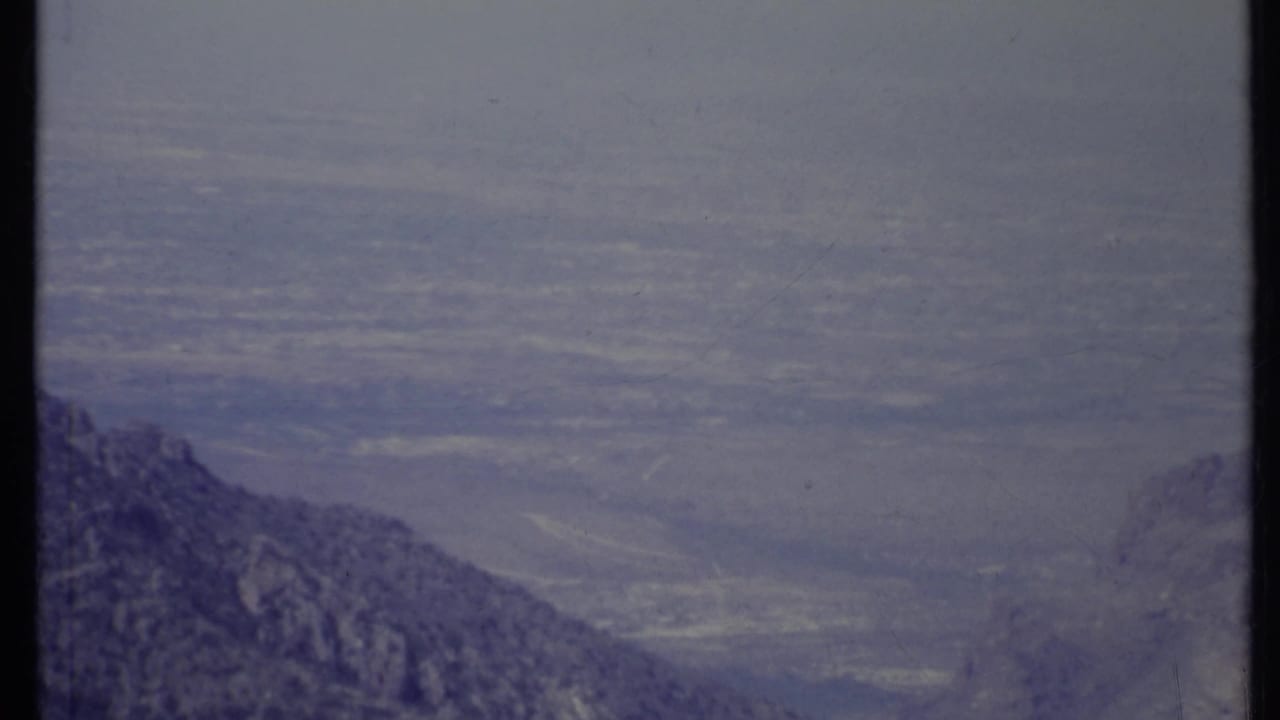 Hazy mountain ridges and a distant valley seen from a high overlook.
