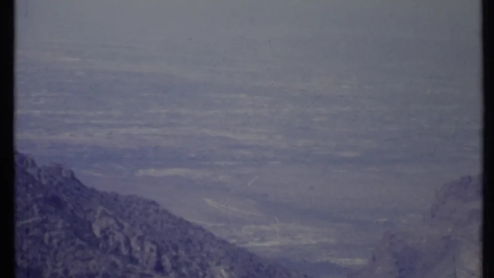 1971 California 8mm frame showing hazy mountain ridges and a broad distant valley from an elevated viewpoint.