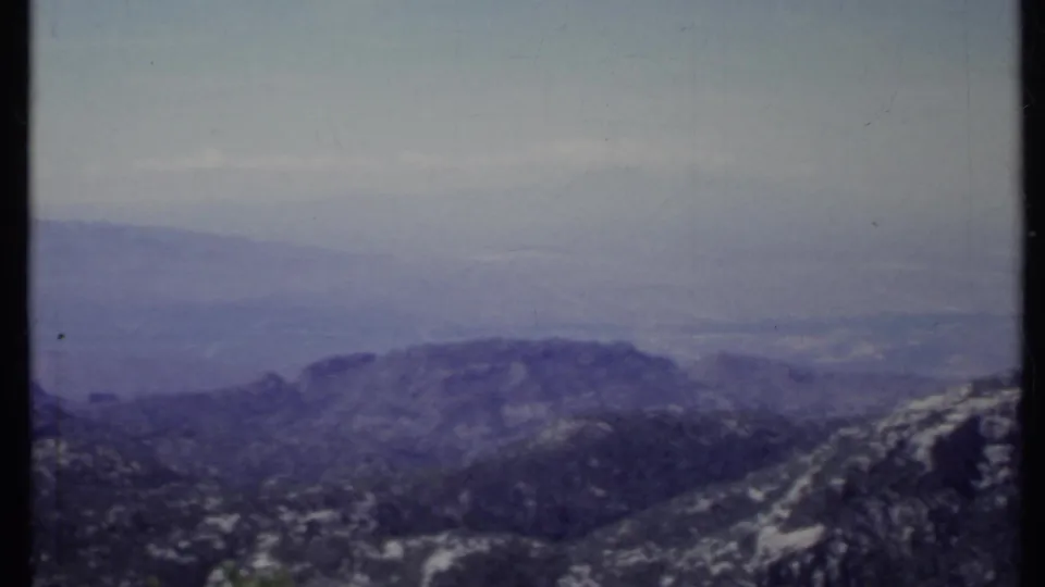 1971 California 8mm frame of a rocky mountain ridge with soft, hazy distance and muted blue-grey film color.